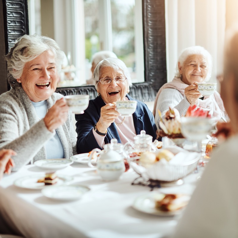 Group of senior women having tea and dessert together