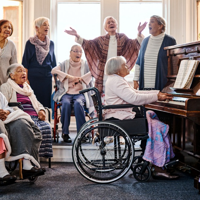 Piano-Pict Group of senior residents singing around the piano