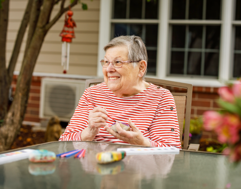 Senior woman working on an rock painting