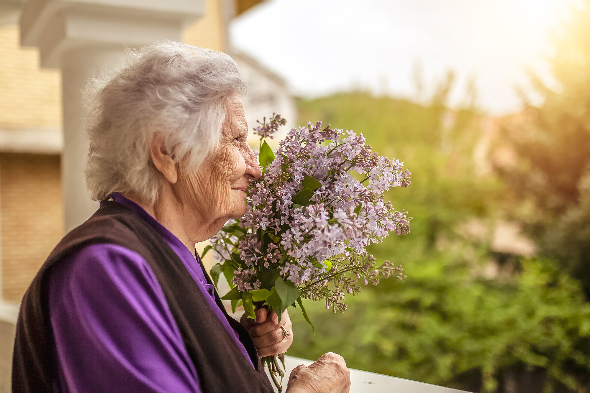 Senior woman smelling lilacs Ten Signs of Dementia